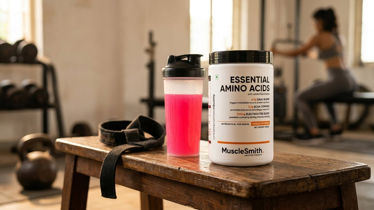 Muscle Smith EAA 6000 Powder tub next to a shaker bottle on a gym bench